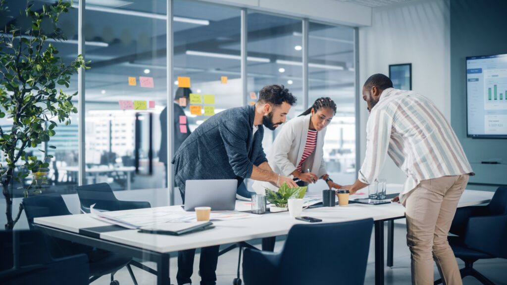 Diverse team of channel partners meeting in office conference room. Creative team around table. Black businesswoman. African-American digital marketing entrepreneur. Hispanic CEO talking.