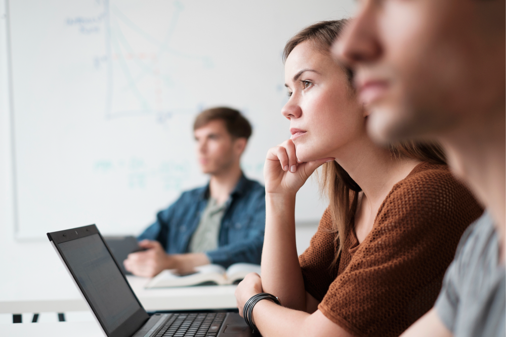 Seven thought leadership strategies B2B marketers need to know. AI generated image of a seated lady with dark hair wearing a blue shirt and holding her apple laptop on her knee.